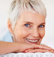 An older woman with dentures smiling